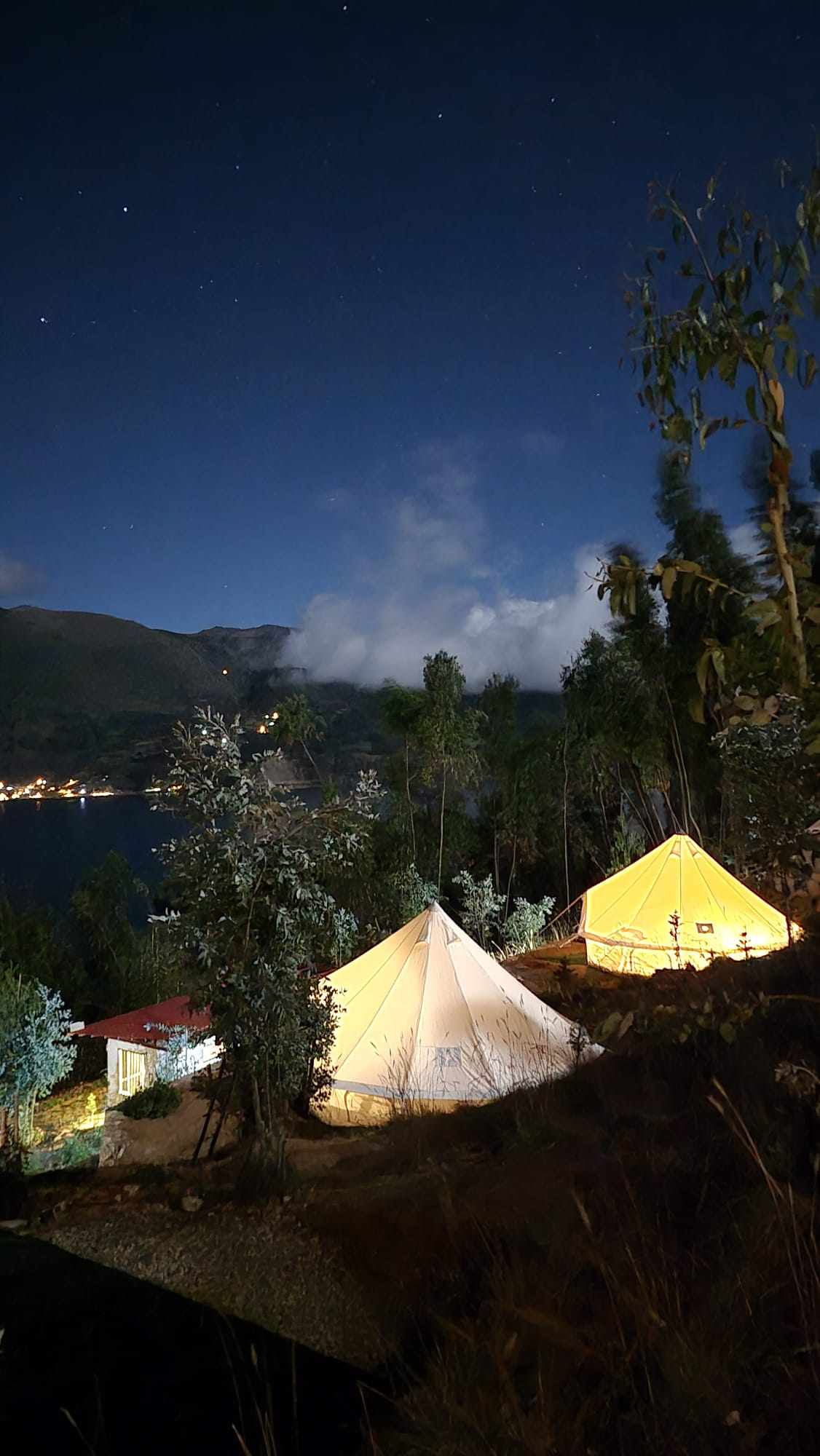 Bell tents de noche con luces y cielo estrellado