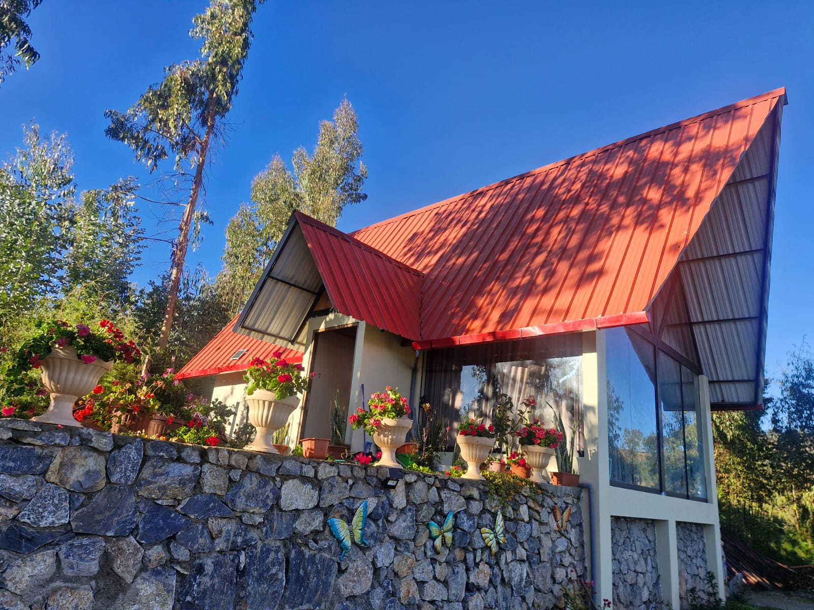Exterior de Casa Alpina con techo rojo y flores