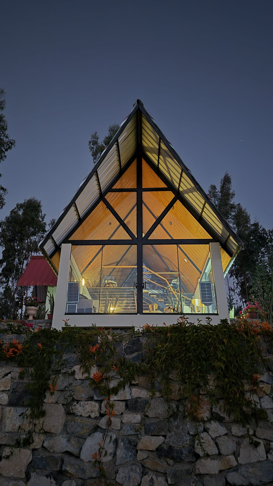 Fachada frontal de Casa Alpina iluminada de noche