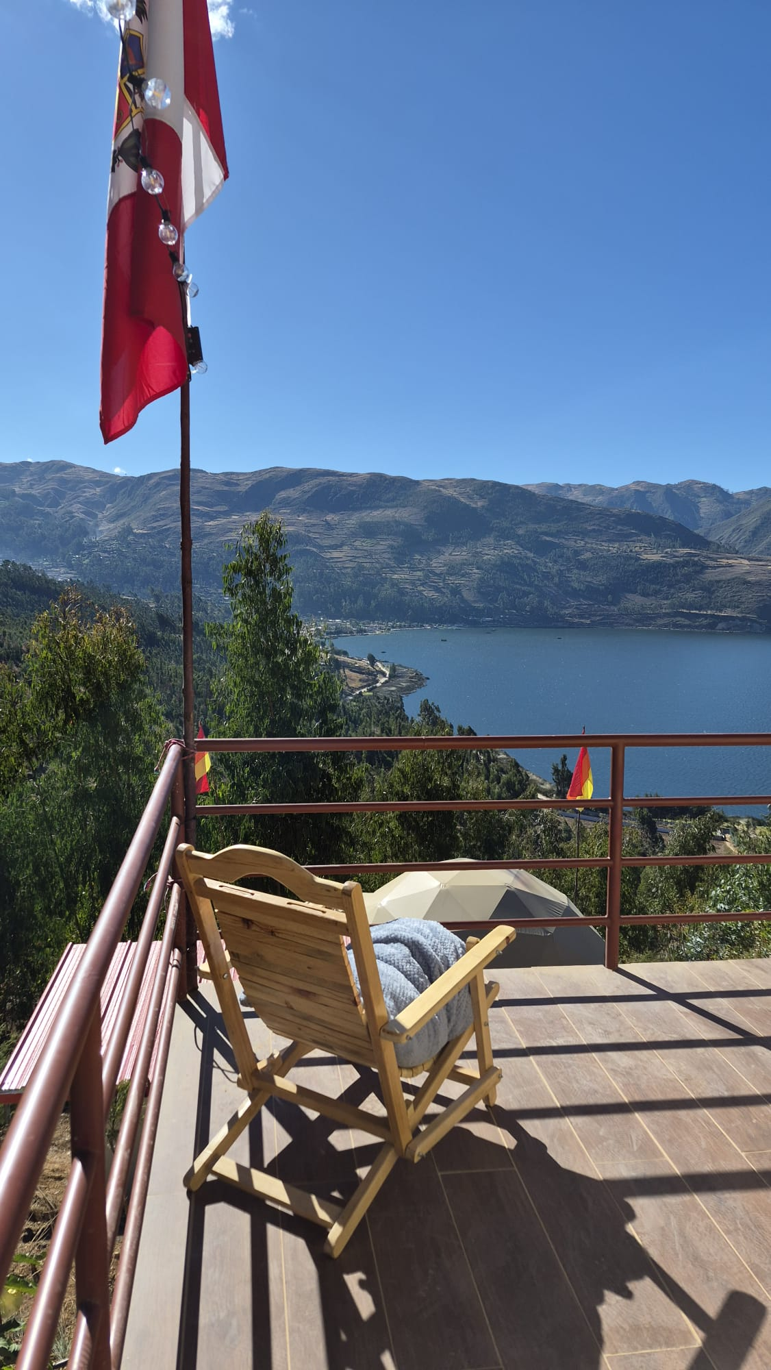 Terraza privada de Los Domos con silla y vista a la laguna