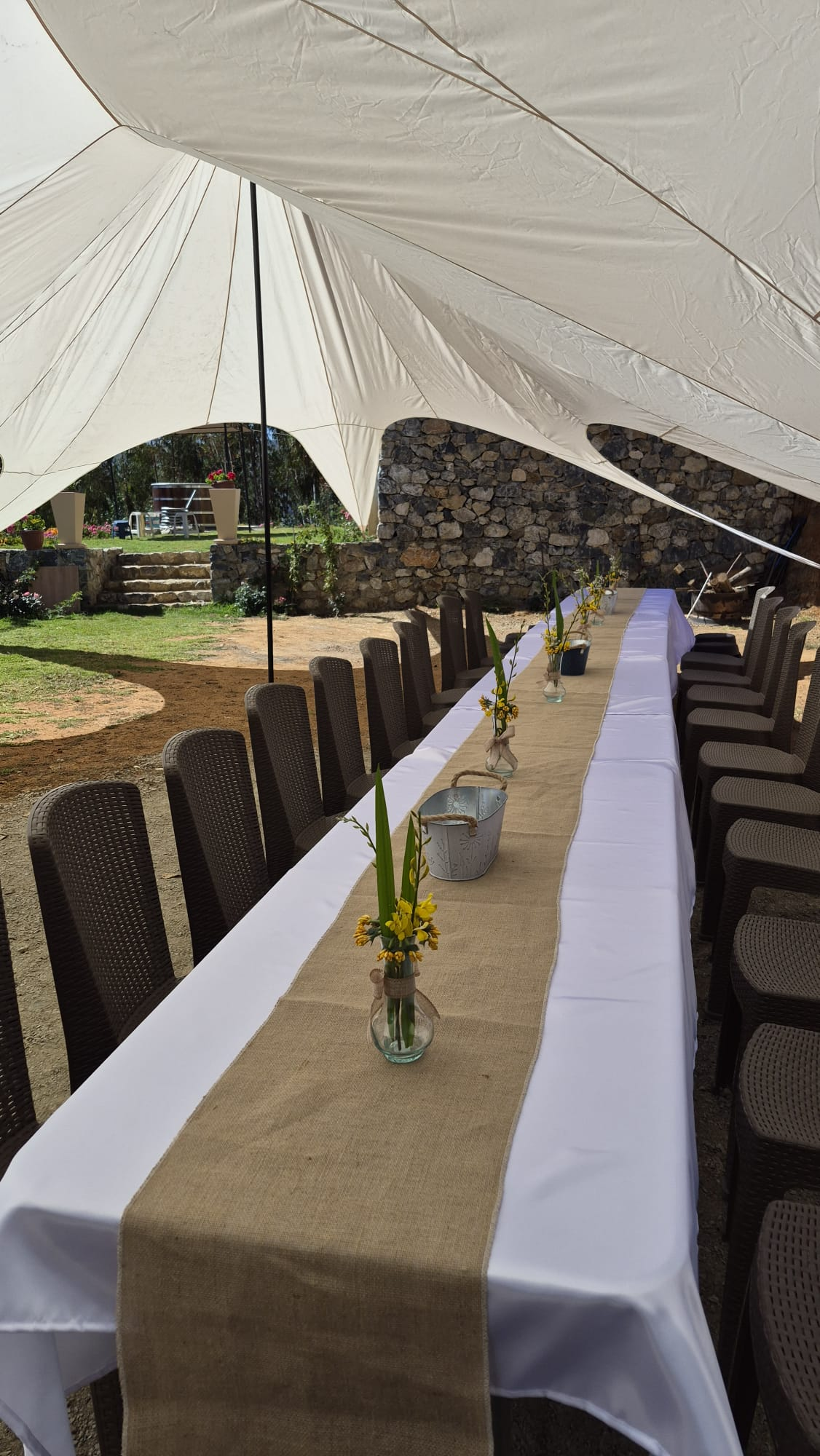 Mesa larga decorada bajo un toldo para compartir