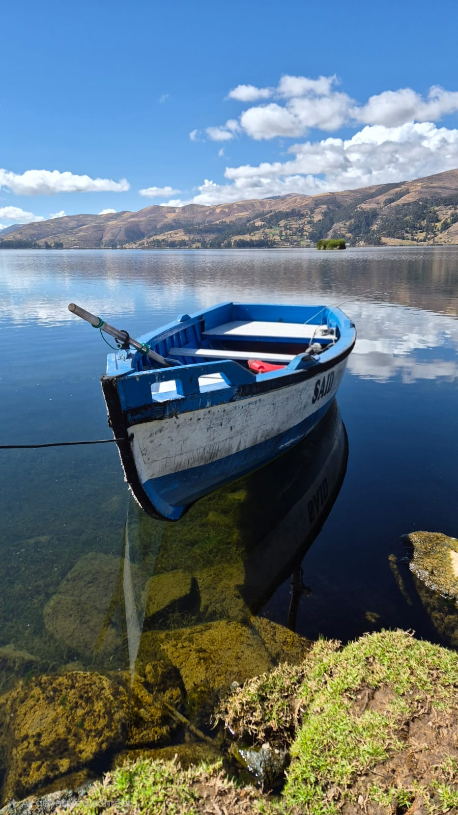 Bote azul reflejado sobre la laguna Pacucha
