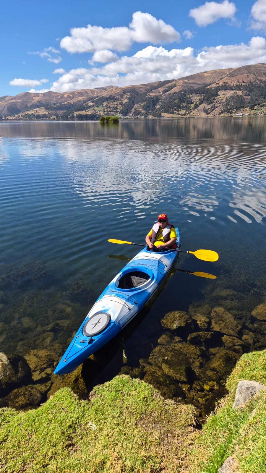 Kayak azul sobre la laguna Pacucha en un día despejado