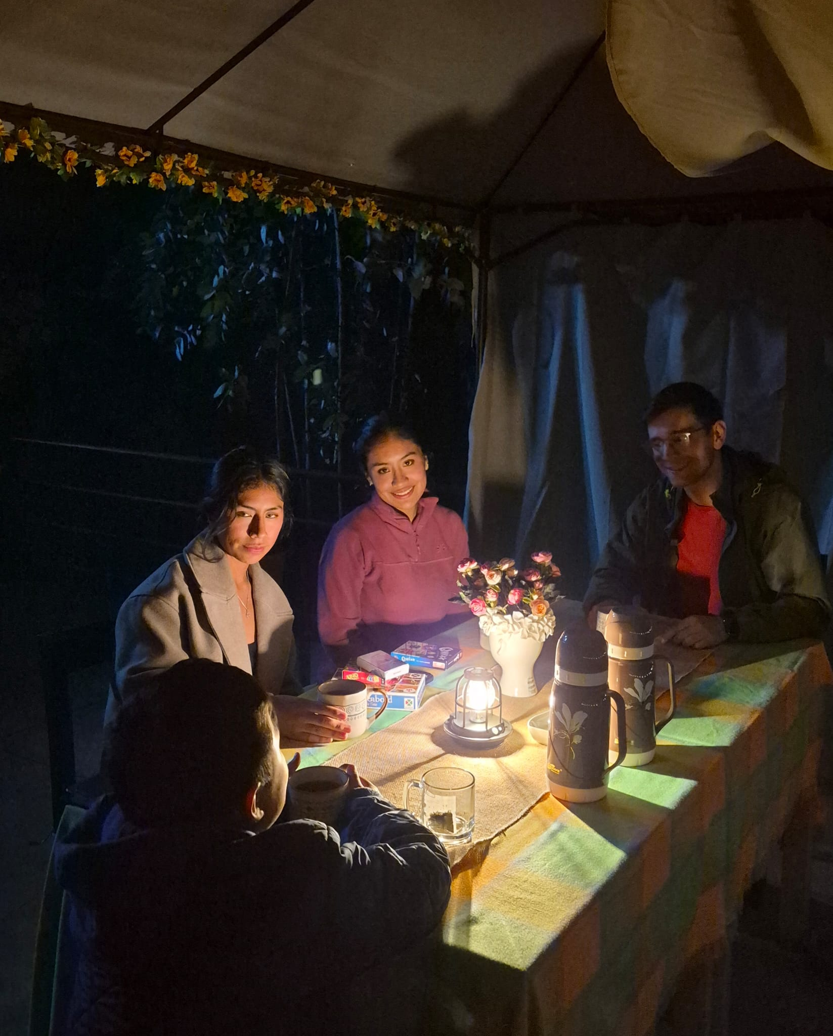 Grupo compartiendo una mesa iluminada durante la noche
