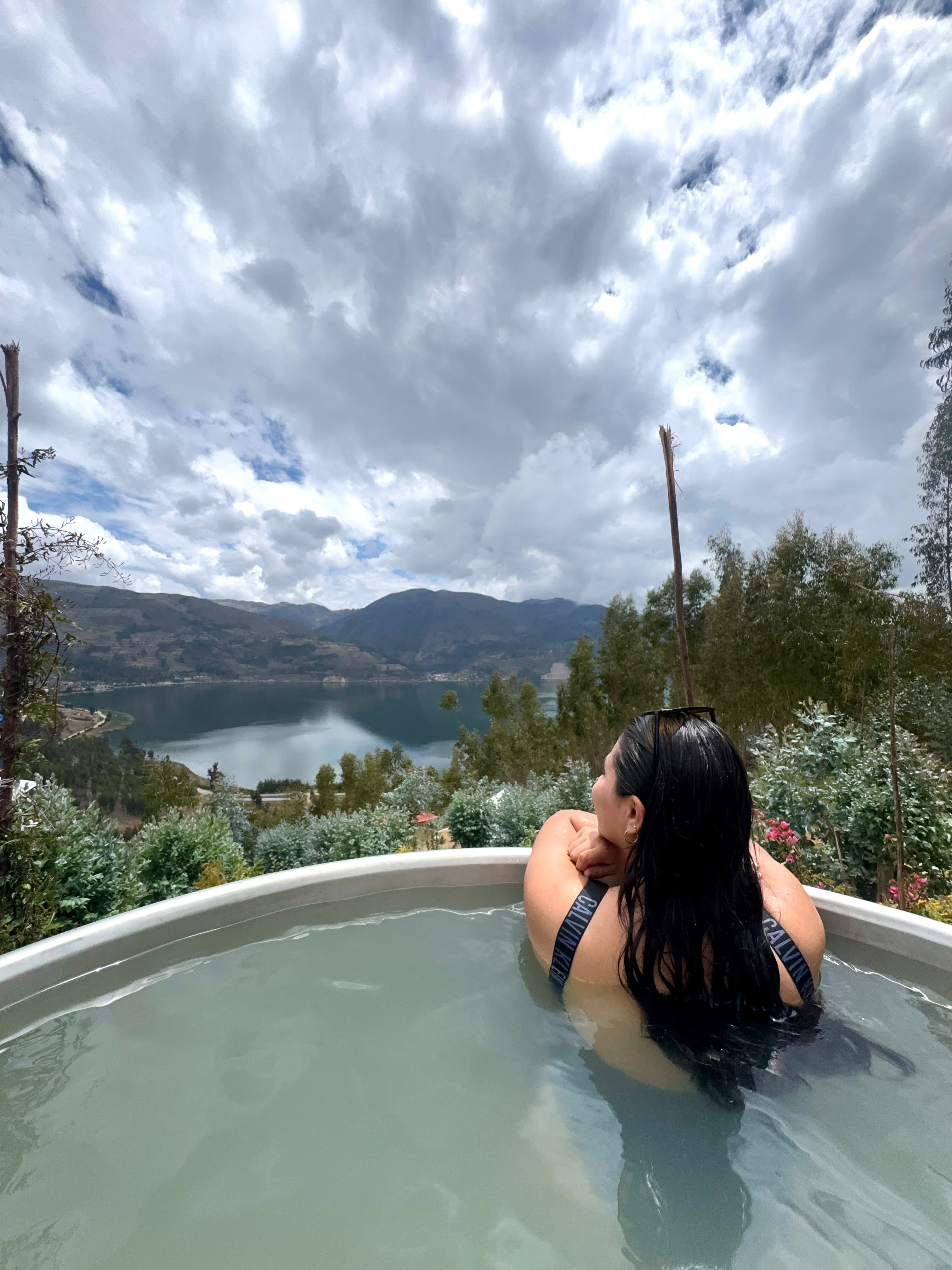 Persona disfrutando una tina caliente con vista a la laguna Pacucha