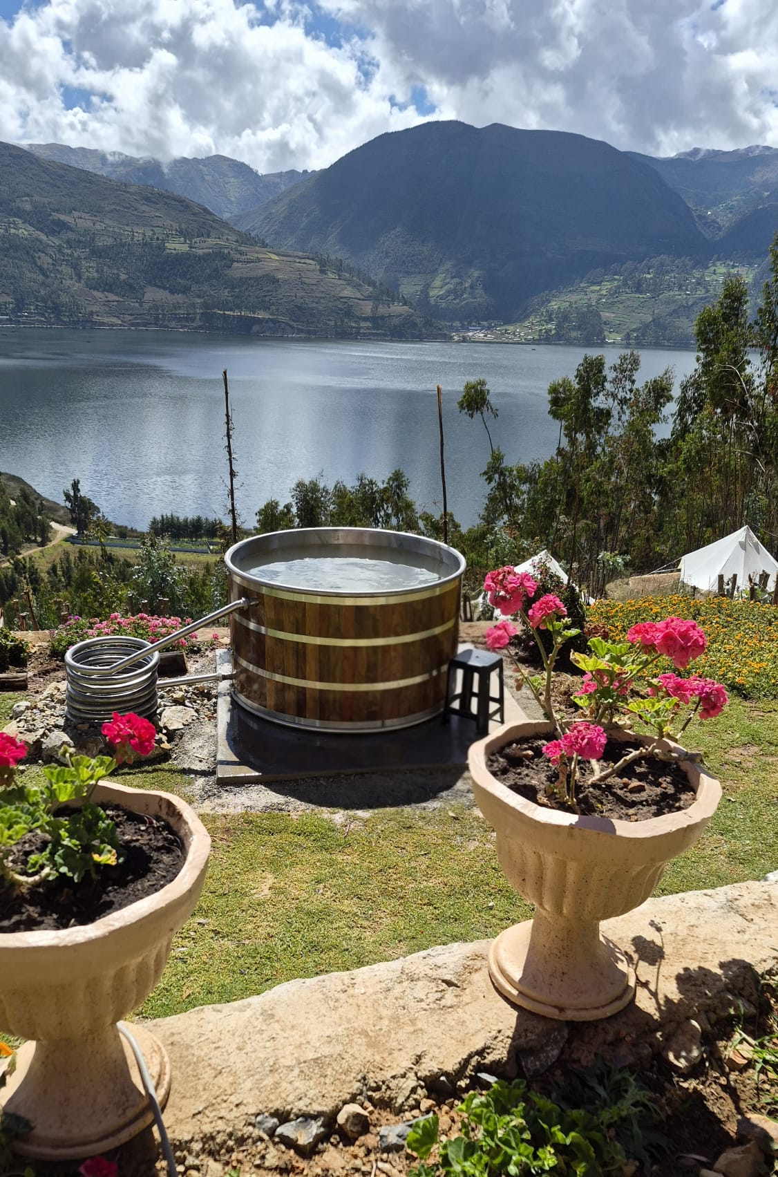 Tina caliente rodeada de flores con vista a la laguna